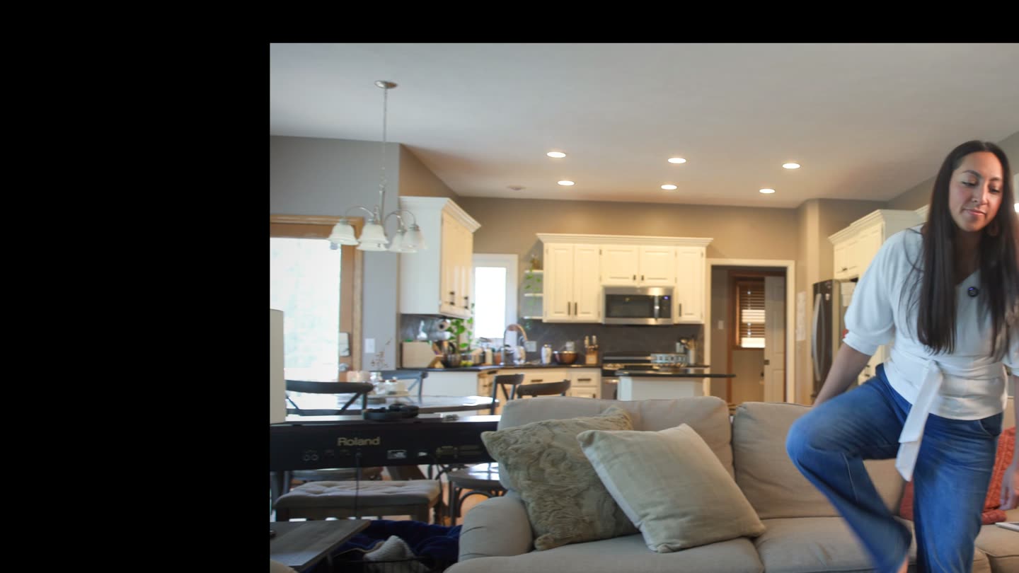 A creator walking onto her living-room set, camera and teleprompter already rolling